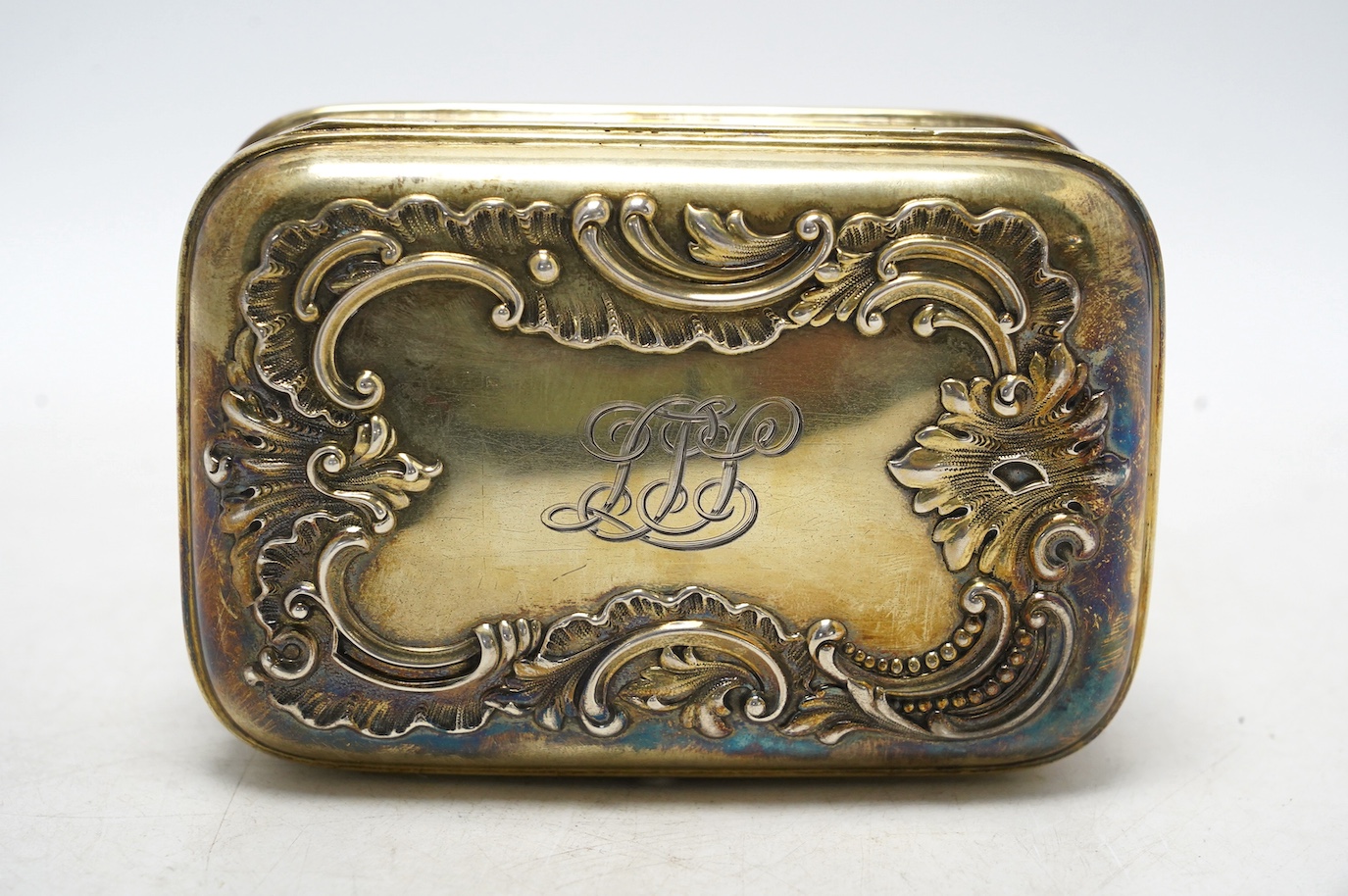 An American sterling trinket box with hinged cover and foliate scroll decoration, engraved with monogram, 13.4cm, gross weight 300 grams. Condition - fair